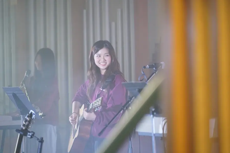 Student guitarist smiling on stage